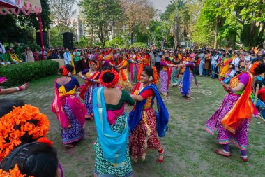Kolkata, Hindistan - 21 Mart 2019: Sari giymiş kız dansçılar, Palash çiçekli geleneksel Hint elbisesi, Butea monosperma, makyaj, Holi festivalinde dans. Hindistan 'a Bahar geliyor..