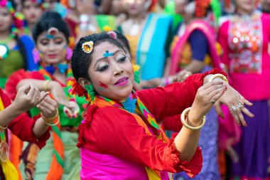 Kolkata, Hindistan - 21 Mart 2019: Sari (geleneksel Hint elbisesi) ve Palash çiçekleri (Butea monosperma) giymiş kız dansçı portresi, Dol 'da (Bengalce) veya Holi' de (Hintçe) dans ederek makyaj).