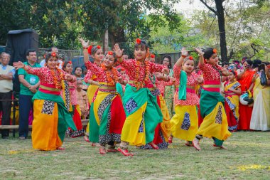 Kolkata, Batı Bengal, Hindistan - 9 Mart 2020: Renkli Hint elbiseleri giymiş, Dol utsab veya Holi festivalinde dans eden gülümseyen genç Bengalli kız dansçılar. Hindistan 'da bahar kutlaması.