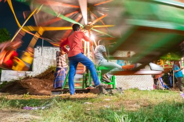 Howrah, Batı Bengal, Hindistan - 14 Nisan 2019: Bengali 'nin ilk yılını kutlamak için geleneksel bir eğlence gezisi olan Nagordola' da çocuklara binişi izleyen kişi. Gajan veya Charak festivali.