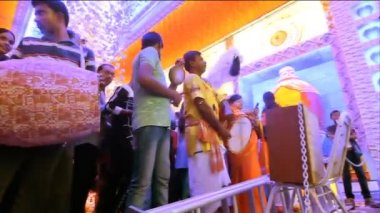 Howrah, Batı Bengal, Hindistan - 5 Ekim 2019: Dhaaks ve kansor ghonta çalınırken, genç purohit Durga 'nın Durga Puja ayini sırasında el yelpazesi kullanılarak tanrıça Durga' ya tapıyor. Düşük açı.