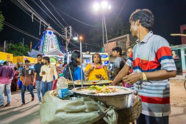 Howrah, Batı Bengal, Hindistan - 14 Nisan 2019: Hint Bengali yemekleri yapan sokak satıcısı, Gajan ya da Charak festivalinde Hindu fanatikleri için bir yol kenarı Bengali yemeği, Bengali yeni yılı, gece.