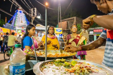 Howrah, Batı Bengal, Hindistan - 14 Nisan 2019: Hint Bengali yemekleri yapan sokak satıcısı, Gajan ya da Charak festivalinde Hindu fanatikleri için bir yol kenarı Bengali yemeği, Bengali yeni yılı, gece.