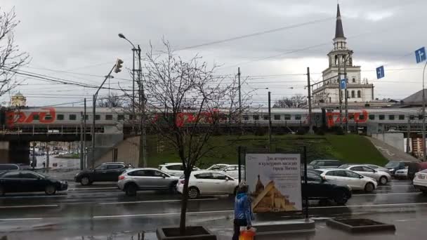 モスクワ ロシア 4月2018 モスクワの交通の眺め 道路を通過する車 バックグラウンドで通過する列車 モスクワの鉄道駅 — ストック動画