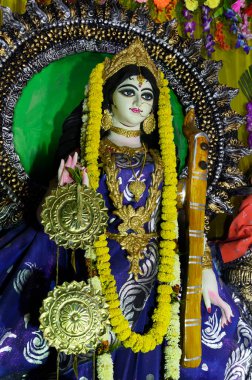 Tanrıça Saraswati 'ye gece tapınılıyor. Hindu tanrıçasına renkli ışık. Howrah, Batı Bengal, Hindistan. Dikey resim.