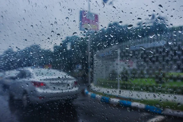 Imagem Tirada Através Gotas Chuva Caindo Vidro Molhado Borrões Abstratos — Fotografia de Stock