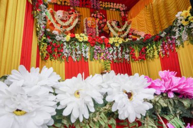 Tanrı 'nın İdolü Jagannath, Balaram ve Suvodra at arabasında. Ratha Jatra festivali Howrah, Batı Bengal, Hindistan 'da. Düşük açılı çekimde odak dışı beyaz çiçekler ön planda.