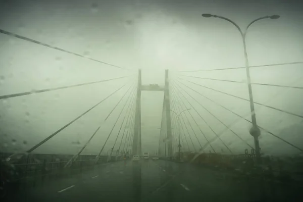 Vidyasagar Setu (Bridge) over river Ganges, known as 2nd Hooghly Bridge in Kolkata,West Bengal, India. Abstract image shot aginst glass with raindrops all over it, monsoon image of Kolkata.