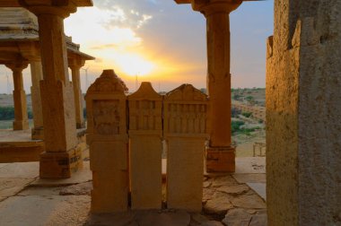 Bada Bagh ya da Barabagh 'daki mezar taşlarının arkasında Jaisalmer, Rajasthan, Hindistan' da Jaisalmer krallarının anıları için yapılmış bir bahçe kompleksi vardır. Turist eğlencesi.