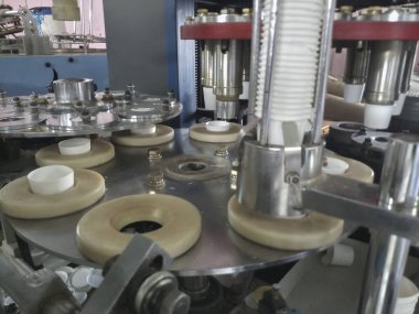 Kağıt bardaklar kağıttan yapılıyor, kağıt bardak üretim makineleri kullanılarak, çalışan bir bardak imalatının veya üretim ünitesinin içerisinden.