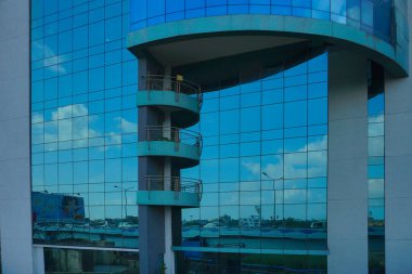 Kolkata, Batı Bengal, Hindistan - 20 Temmuz 2019: Binaların modern mimarisi, cam dış görünüş mavi gökyüzünü, beyaz bulutları ve binaları yansıtıyor.