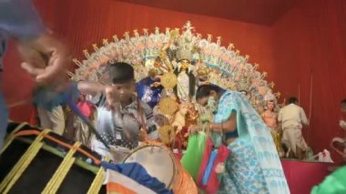 Howrah, Batı Bengal, Hindistan - 24 Ekim 2020: Dhaakis dhaaks oynarken tanrıça Durga papaz tarafından ibadet ediliyor. Durga 'nın Bengal' de kızı olarak görüldüğü gibi yaşlı kadın da Tanrıça için sari sunuyor..