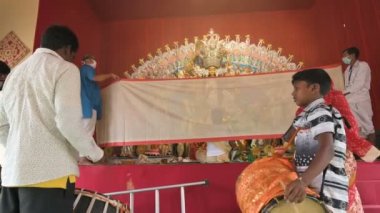 Howrah, Batı Bengal, Hindistan - 24 Ekim 2020: Dhaakis vog yaparken dhaaks oynuyor, kutsal yemek Tanrıça Durga 'ya sunuluyor. İdolü, Bengalli kadınların giydiği Sari ile kaplı..