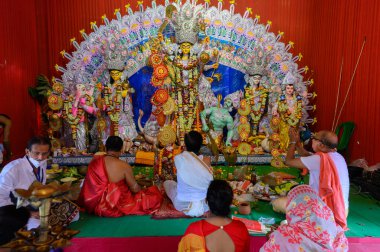 Howrah, Batı Bengal, Hindistan - 25 Ekim 2020: Sondhipujo aarti sırasında Hindu rahipler tanrıça Durga 'ya tapıyorlar. Covid 19 salgını sırasında Durga puja.