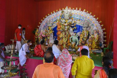 Howrah, Batı Bengal, Hindistan - 25 Ekim 2020: Sondhipujo aarti sırasında Hindu rahipler tanrıça Durga 'ya tapıyorlar. Covid 19 salgını sırasında Durga puja.