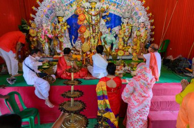 Howrah, Batı Bengal, Hindistan - 25 Ekim 2020: Sondhipujo aarti sırasında Hindu rahipler tanrıça Durga 'ya tapıyorlar. Covid 19 salgını sırasında Durga puja.