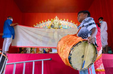 Howrah, Batı Bengal, Hindistan - 24 Ekim 2020: Dhaakis vog yaparken dhaaks oynuyor, kutsal yemek Tanrıça Durga 'ya sunuluyor. İdolü, Bengalli kadınların giydiği Sari ile kaplı..