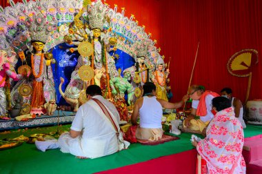 Howrah, Batı Bengal, Hindistan - 25 Ekim 2020: Hindu purohit maskeli Hindu dindarına tilak takıyor. Durga Puja Salgın Festivali, Hinduizm 'in en büyük festivali.