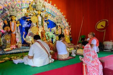 Howrah, Batı Bengal, Hindistan - 25 Ekim 2020: Hindu purohit maskeli Hindu kadın tilak takıyor. Durga Puja Salgın Festivali, Hinduizm 'in en büyük festivali.