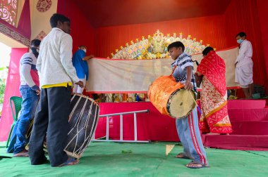 Howrah, Batı Bengal, Hindistan - 24 Ekim 2020: Dhaakis vog yaparken dhaaks oynuyor, kutsal yemek Tanrıça Durga 'ya sunuluyor. İdolü, Bengalli kadınların giydiği Sari ile kaplı..