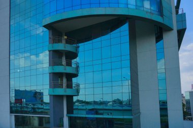 Kolkata, Batı Bengal, Hindistan - 20 Temmuz 2019: Binaların modern mimarisi, cam dış görünüş mavi gökyüzünü, beyaz bulutları ve binaları yansıtıyor.