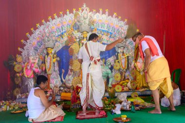 Howrah, Batı Bengal, Hindistan - 25 Ekim 2020: Maskeli Hindu purohit kutsamaları aarti sırasında kutsal oda ile maskeli Hindu dindarları kutsadı. Tanrıça Durga 'ya tapılıyor. Durga Puja Festivali.