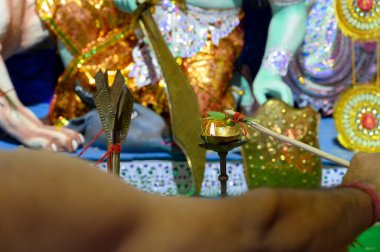 Kutsal alev, tanrıça Durga 'nın Pran Protistha' sı için çubuğa bağlanmış belpata 'yı temizliyor. Hindu rahiplere taparak puja, Howrah, Batı Bengal, Hindistan' da Durga Puja festivali..