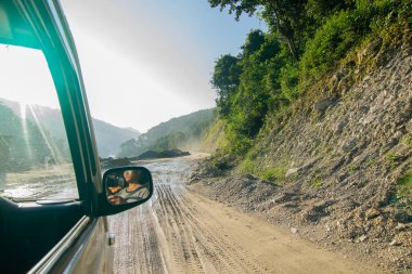 Sikkim, Hindistan - 15.10.2016: Sikkim yolu üzerindeki Himalaya dağlarında yeniden inşa edilmiş yoldan geçen araba. Küresel ısınma, şiddetli yağış ve iklim değişikliğinin etkileri.