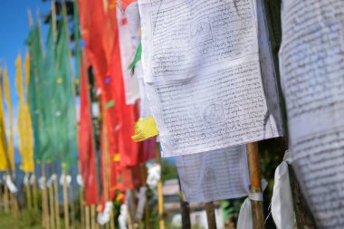 Beyaz bayraklar üzerinde Tibet Budist yazıtları bulunan renkli Budist dua bayrakları, sonsuz barış hakkında. Güzel Rinchen Chholing Manastırında. Rinchenpong, Sikkim, Hindistan. İzinle resim çekimi.
