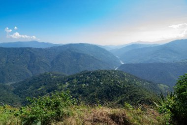 View of Himalayan mountain, blue sky and forest from Tarey Bhir point, tourist spot, Sikkim, India. 'Bhir' means cliff in the local language,about 10,000 feet long path, breathtaking view at the edge.