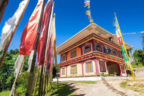 Renkli Buddist dua bayraklarıyla güzel Rinchen Chholing Manastırı, berrak mavi gökyüzü ve arka planda Himalaya dağları. Rinchenpong, Sikkim, Hindistan.
