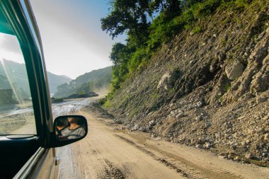 Himalaya Dağları 'ndan Sikkim' e giden yolda yeniden inşa edilmiş yoldan geçen araba. Küresel ısınma, sağanak yağış ve iklim değişikliğinin etkileri. Sikkim, Hindistan.
