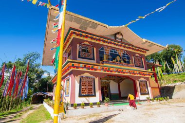 Renkli Buddist dua bayraklarıyla güzel Rinchen Chholing Manastırı, berrak mavi gökyüzü ve arka planda Himalaya dağları. Rinchenpong, Sikkim, Hindistan.