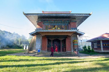 Rinchenpong, Sikkim, Hindistan - 18.10.2016: Rinchenpong Manastırı önünde oynayan kırmızı elbiseli Budist rahipler ve çocuklar. Çocukluk sevinci. Arka planda Himalaya Dağları.