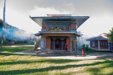 Rinchenpong, Sikkim, Hindistan - 18.10.2016: Rinchenpong Manastırı önünde oynayan kırmızı elbiseli Budist rahipler ve çocuklar. Çocukluk sevinci. Arka planda Himalaya Dağları.