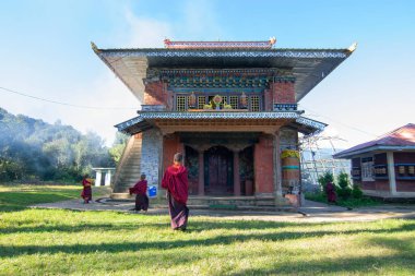 Rinchenpong, Sikkim, Hindistan - 18.10.2016: Rinchenpong Manastırı önünde oynayan kırmızı elbiseli Budist rahipler ve çocuklar. Çocukluk sevinci. Arka planda Himalaya Dağları.
