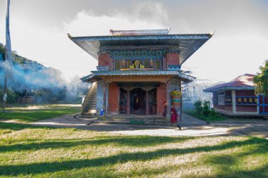 Rinchenpong, Sikkim, Hindistan - 18.10.2016: Rinchenpong Manastırı önünde oynayan kırmızı elbiseli Budist rahipler ve çocuklar. Çocukluk sevinci. Arka planda Himalaya Dağları.