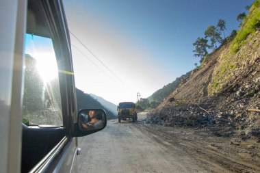 Sikkim, Hindistan - 15.10.2016: Sikkim yolu üzerindeki Himalaya dağlarında yeniden inşa edilmiş yoldan geçen araba. Küresel ısınma, şiddetli yağış ve iklim değişikliğinin etkileri.