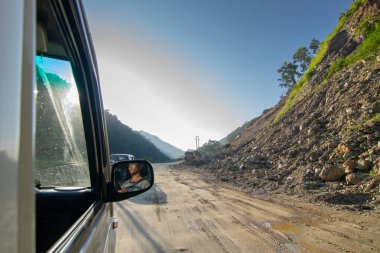 Sikkim, Hindistan - 15.10.2016: Sikkim yolu üzerindeki Himalaya dağlarında yeniden inşa edilmiş yoldan geçen araba. Küresel ısınma, şiddetli yağış ve iklim değişikliğinin etkileri.