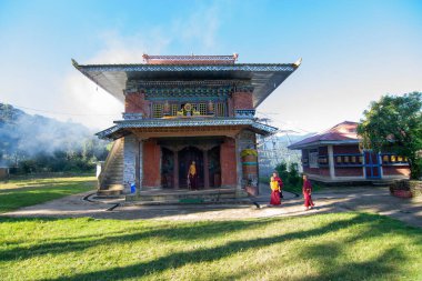 Rinchenpong, Sikkim, Hindistan - 18.10.2016: Rinchenpong Manastırı önünde oynayan kırmızı elbiseli Budist rahipler ve çocuklar. Çocukluk sevinci. Arka planda Himalaya Dağları.