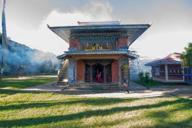 Rinchenpong, Sikkim, Hindistan - 18.10.2016: Rinchenpong Manastırı önünde oynayan kırmızı elbiseli Budist rahipler ve çocuklar. Çocukluk sevinci. Arka planda Himalaya Dağları.