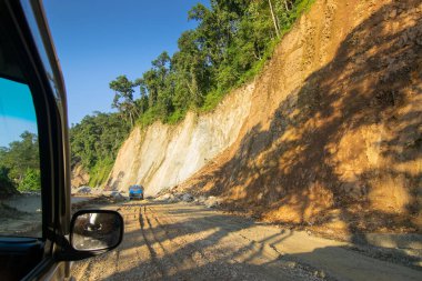 Sikkim, Hindistan - 15.10.2016: Sikkim yolu üzerindeki Himalaya dağlarında yeniden inşa edilmiş yoldan geçen araba. Küresel ısınma, şiddetli yağış ve iklim değişikliğinin etkileri.