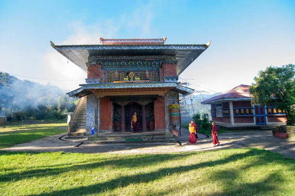 Rinchenpong, Sikkim, Hindistan - 18.10.2016: Rinchenpong Manastırı önünde oynayan kırmızı elbiseli Budist rahipler ve çocuklar. Çocukluk sevinci. Arka planda Himalaya Dağları.