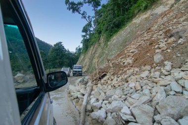 Sikkim, Hindistan - 15.10.2016: Sikkim yolu üzerindeki Himalaya dağlarında yeniden inşa edilmiş yoldan geçen araba. Küresel ısınma, şiddetli yağış ve iklim değişikliğinin etkileri.