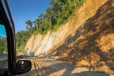 Sikkim, Hindistan - 15.10.2016: Sikkim yolu üzerindeki Himalaya dağlarında yeniden inşa edilmiş yoldan geçen araba. Küresel ısınma, şiddetli yağış ve iklim değişikliğinin etkileri.
