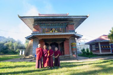 Rinchenpong, Sikkim, Hindistan - 18.10.2016: Rinchenpong Manastırı önünde kırmızı elbiseli Budist rahipler ve çocuklar. Çocukluk sevinci. Arka planda Himalaya Dağları.