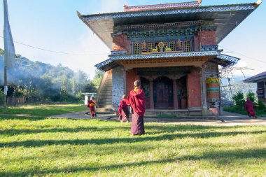 Rinchenpong, Sikkim, Hindistan - 18.10.2016: Rinchenpong Manastırı önünde oynayan kırmızı elbiseli Budist rahipler ve çocuklar. Çocukluk sevinci. Arka planda Himalaya Dağları.