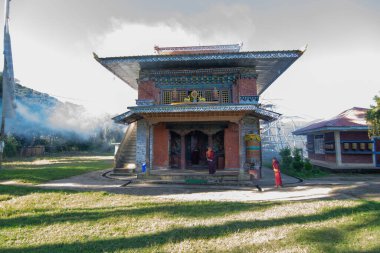 Rinchenpong, Sikkim, Hindistan - 18.10.2016: Rinchenpong Manastırı önünde oynayan kırmızı elbiseli Budist rahipler ve çocuklar. Çocukluk sevinci. Arka planda Himalaya Dağları.