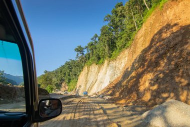 Sikkim, Hindistan - 15.10.2016: Sikkim yolu üzerindeki Himalaya dağlarında yeniden inşa edilmiş yoldan geçen araba. Küresel ısınma, şiddetli yağış ve iklim değişikliğinin etkileri.