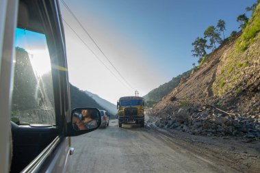 Sikkim, Hindistan - 15.10.2016: Sikkim yolu üzerindeki Himalaya dağlarında yeniden inşa edilmiş yoldan geçen araba. Küresel ısınma, şiddetli yağış ve iklim değişikliğinin etkileri.